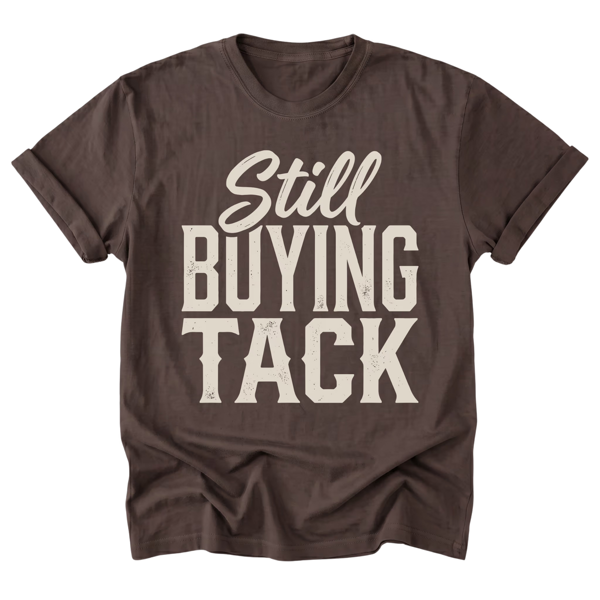 A dark brown t-shirt with a distressed off-white graphic text reading 'Still BUYING TACK' on the front, displayed against a solid white background.