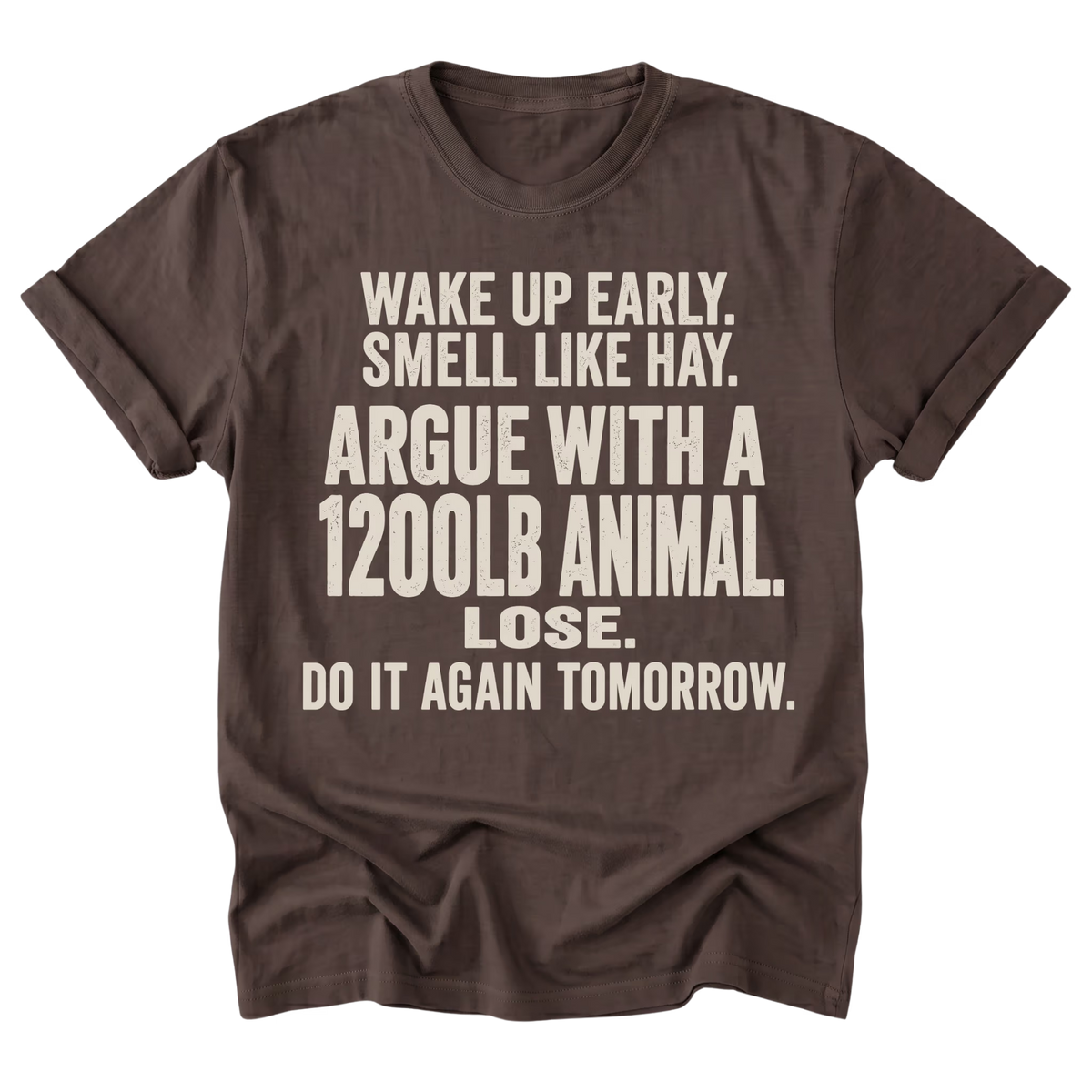 A dark brown short-sleeve t-shirt with a humorous text graphic printed in a light beige/cream color, displayed flat against a solid white background.