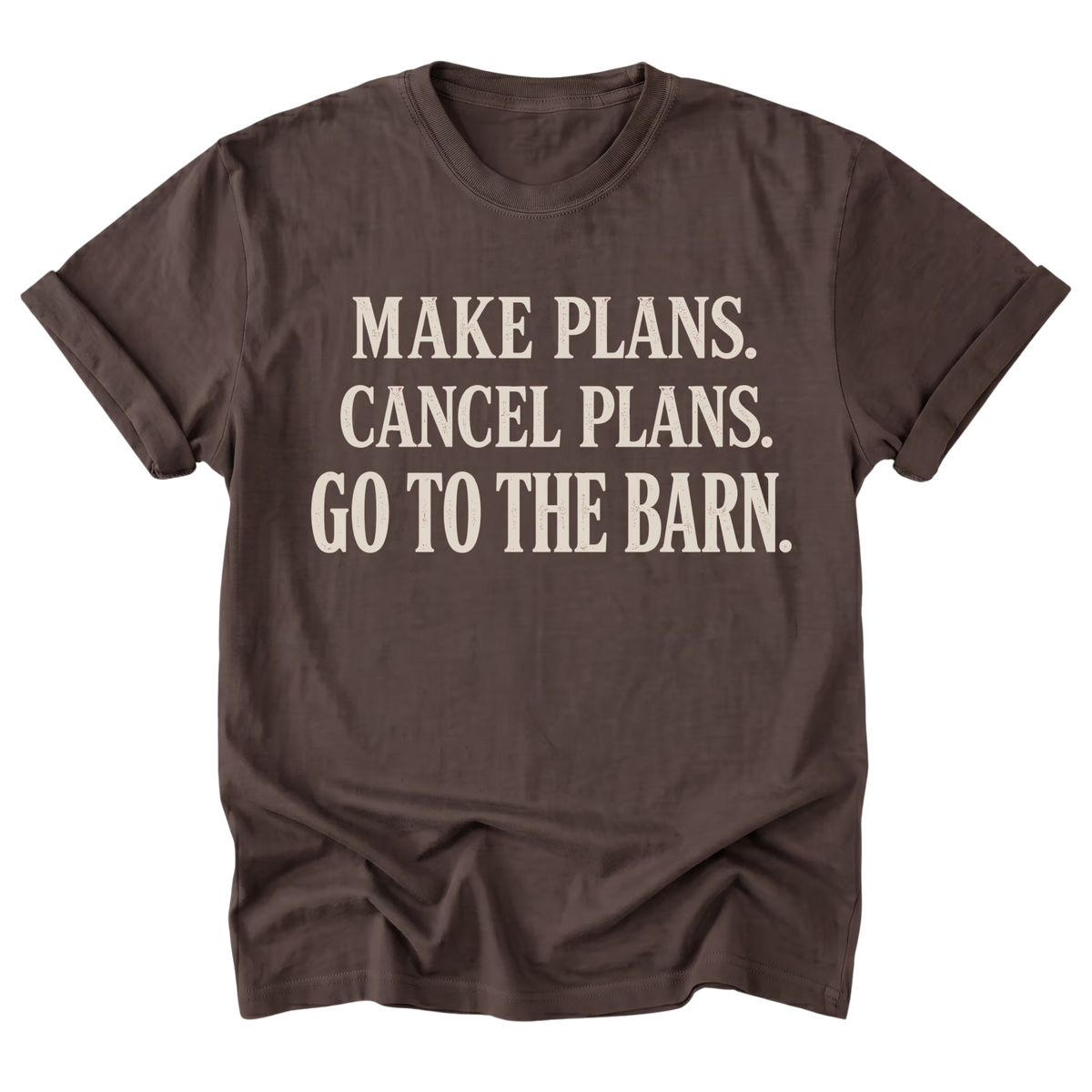 A dark brown short-sleeve t-shirt with rolled-up sleeves and a vintage-style cream-colored text graphic on the front that reads 'MAKE PLANS. CANCEL PLANS.