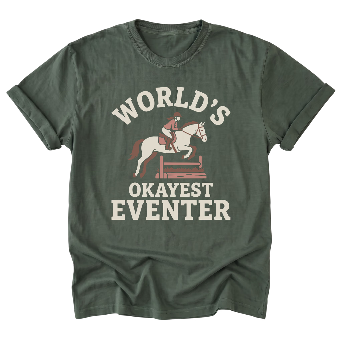 A military green short-sleeve t-shirt with a vintage-style graphic on the front that reads 'WORLD'S OKAYEST EVENTER' in cream lettering, featuring an illustration of a horse and rider jumping a hurdle.