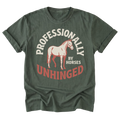 A military green short-sleeve t-shirt with a graphic print featuring a light pink horse and the text 'PROFESSIONALLY UNHINGED' in cream and red, displayed on a clean white background.