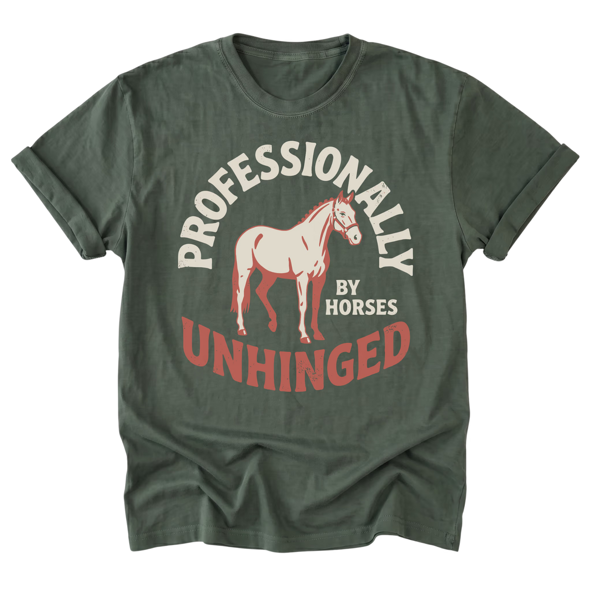 A military green short-sleeve t-shirt with a graphic print featuring a light pink horse and the text 'PROFESSIONALLY UNHINGED' in cream and red, displayed on a clean white background.