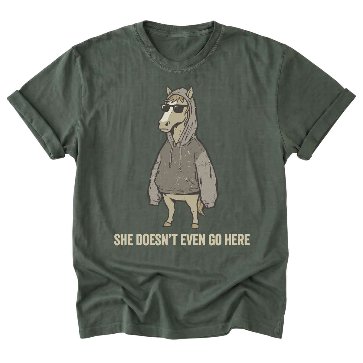 A military green graphic t-shirt of a horse wearing a hoodies and sunglasses with the text "She Doesn't Even Go Here" at the bottom