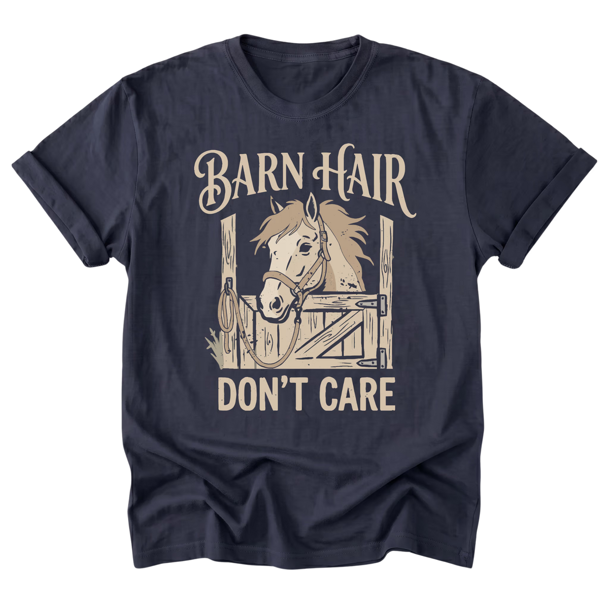 A navy blue short-sleeve t-shirt with a graphic print of a horse in a barn stall and the text 'BARN HAIR DON'T CARE' in a beige font, shown on a plain white background.