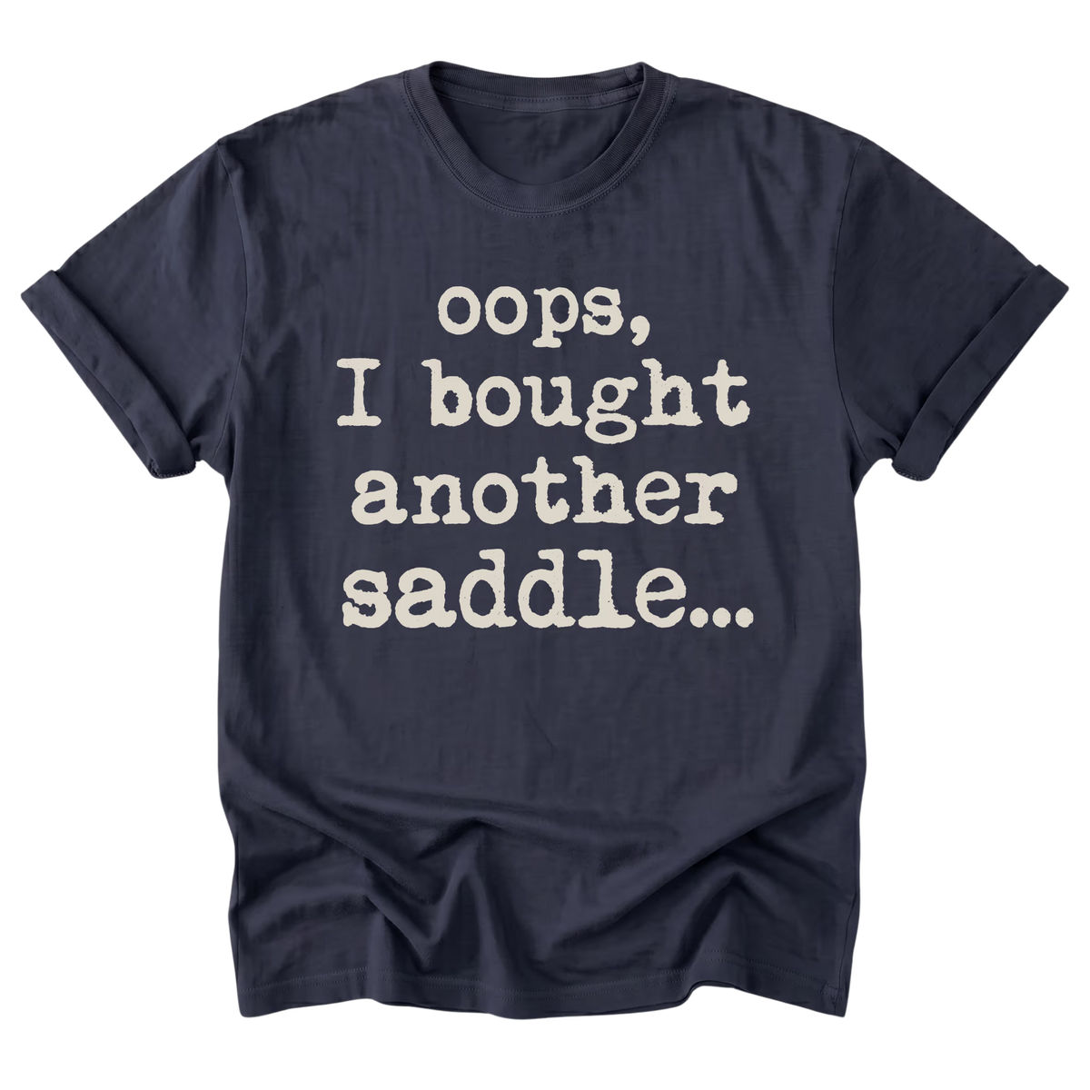 A navy blue short-sleeve t-shirt with rolled-up sleeves and a distressed white typewriter-style text print that reads 'oops, I bought another saddle.