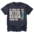 A navy blue short-sleeve t-shirt with a graphic print that reads 'MY HORSE HAS BETTER HEALTHCARE THAN I DO' next to an illustration of a horse leg wrapped in teal bandages and a brown hoof, shown on a plain white background.