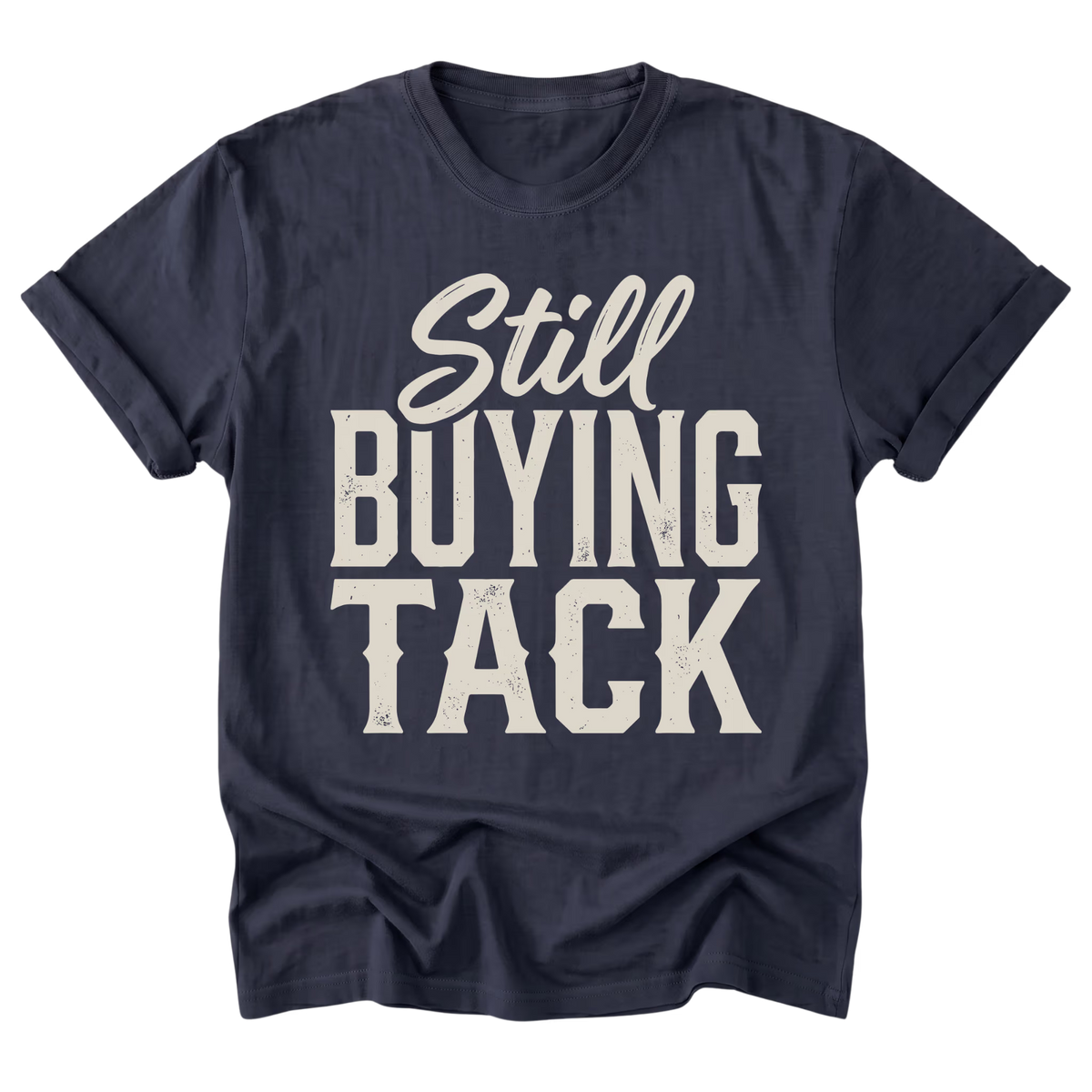 A navy blue short-sleeve t-shirt with a distressed white graphic print that reads 'Still BUYING TACK' on the front, displayed against a solid white background.