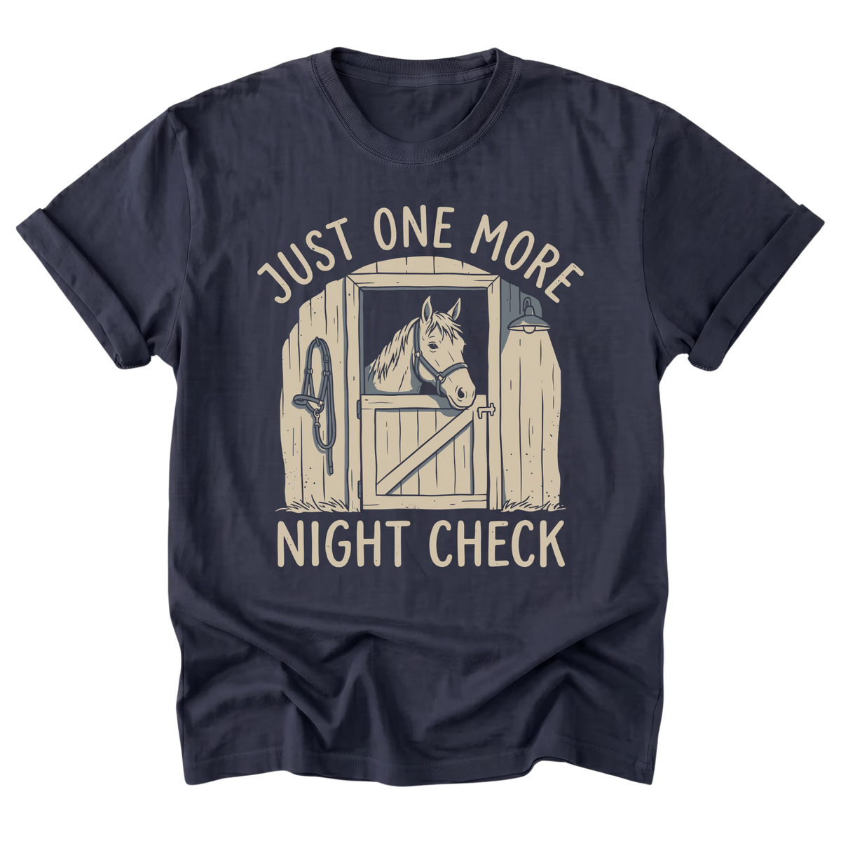 A navy blue short-sleeve t-shirt with a graphic print of a horse in a stable door and the text 'JUST ONE MORE NIGHT CHECK' in a light beige color, displayed on a solid white background.