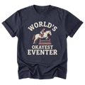 A navy blue short-sleeve t-shirt with a vintage-style graphic on the front. The graphic features a white horse with a rider jumping over a wooden fence, with the text 'WORLD'S OKAYEST EVENTER' printed in white and light brown.
