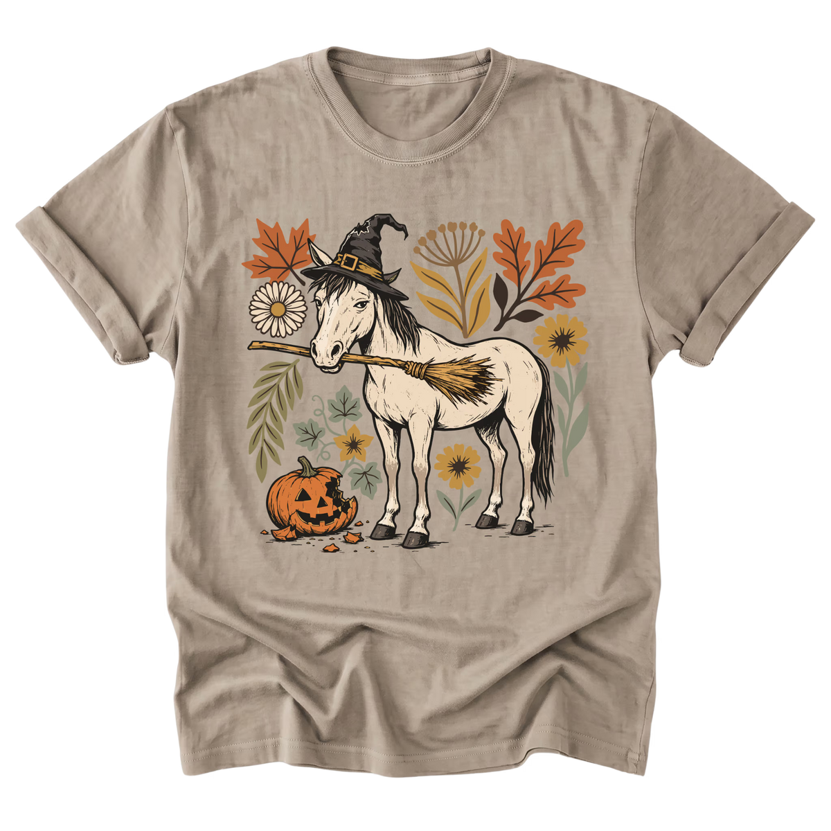 A sand beige crewneck t-shirt featuring a graphic illustration of a white horse dressed as a witch with a black hat and broom, surrounded by autumn leaves, flowers, and a jack-o'-lantern pumpkin.