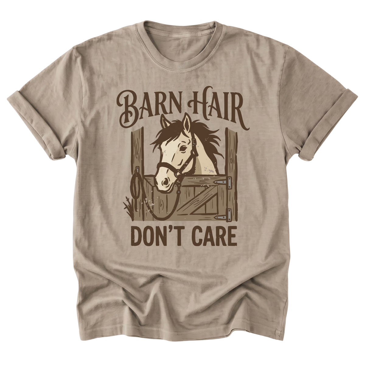 A beige sand short-sleeve t-shirt with a brown graphic print of a horse in a stable and the text 'BARN HAIR DON'T CARE'.