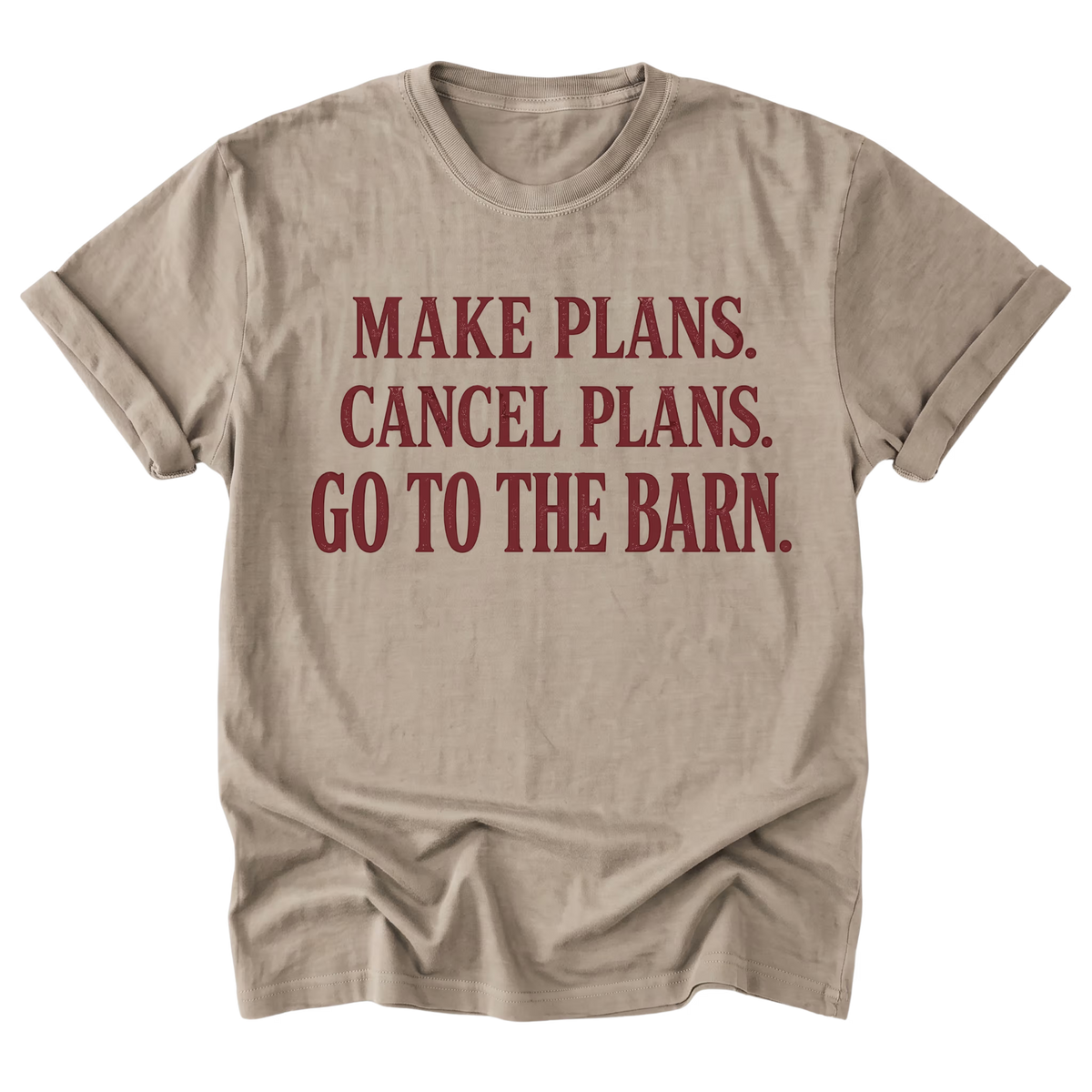 A beige sand crewneck t-shirt with rolled sleeves, featuring the text 'MAKE PLANS. CANCEL PLANS.